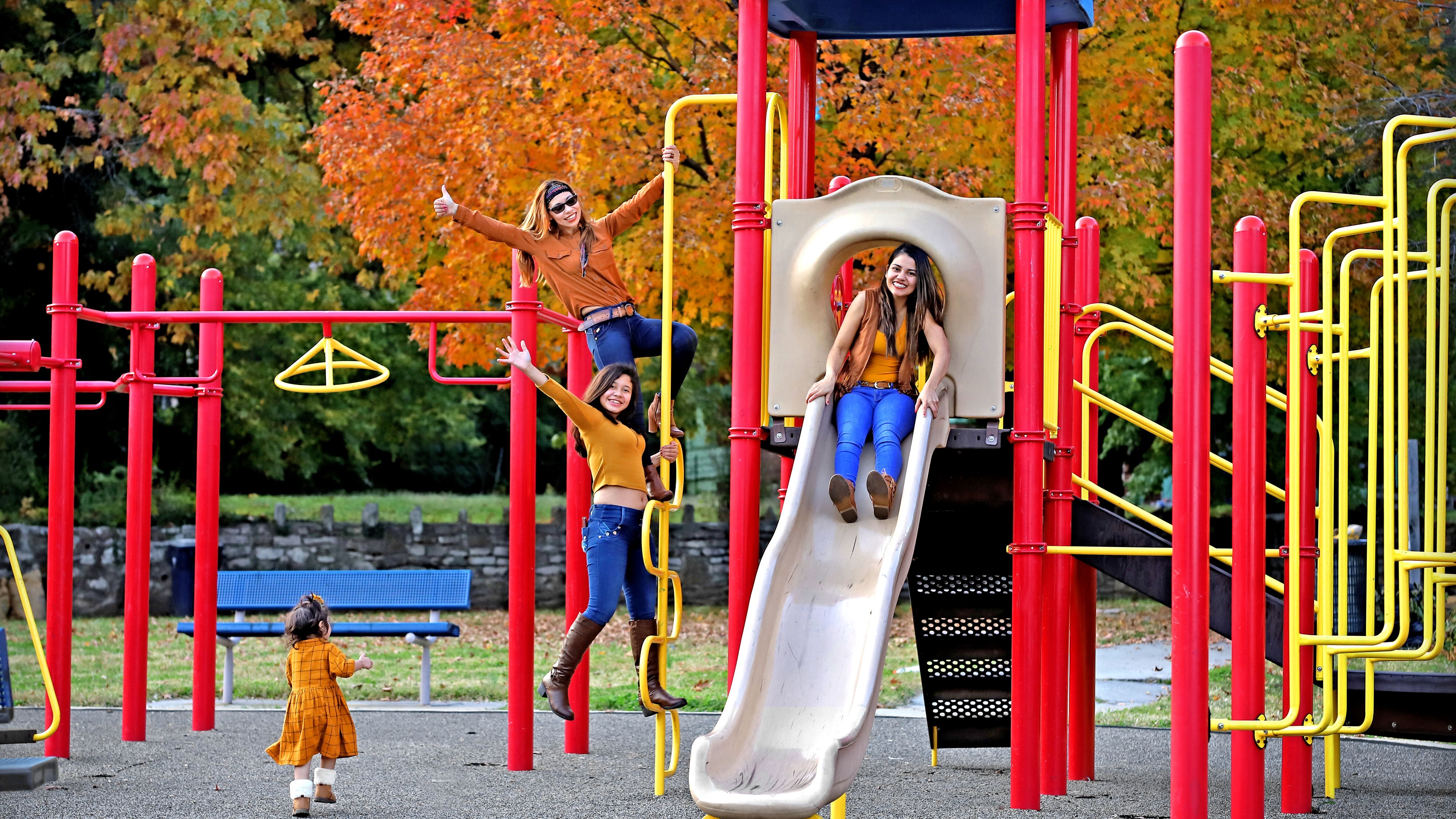 People dressed in fall colors posing for a picture in the fall on the slide set