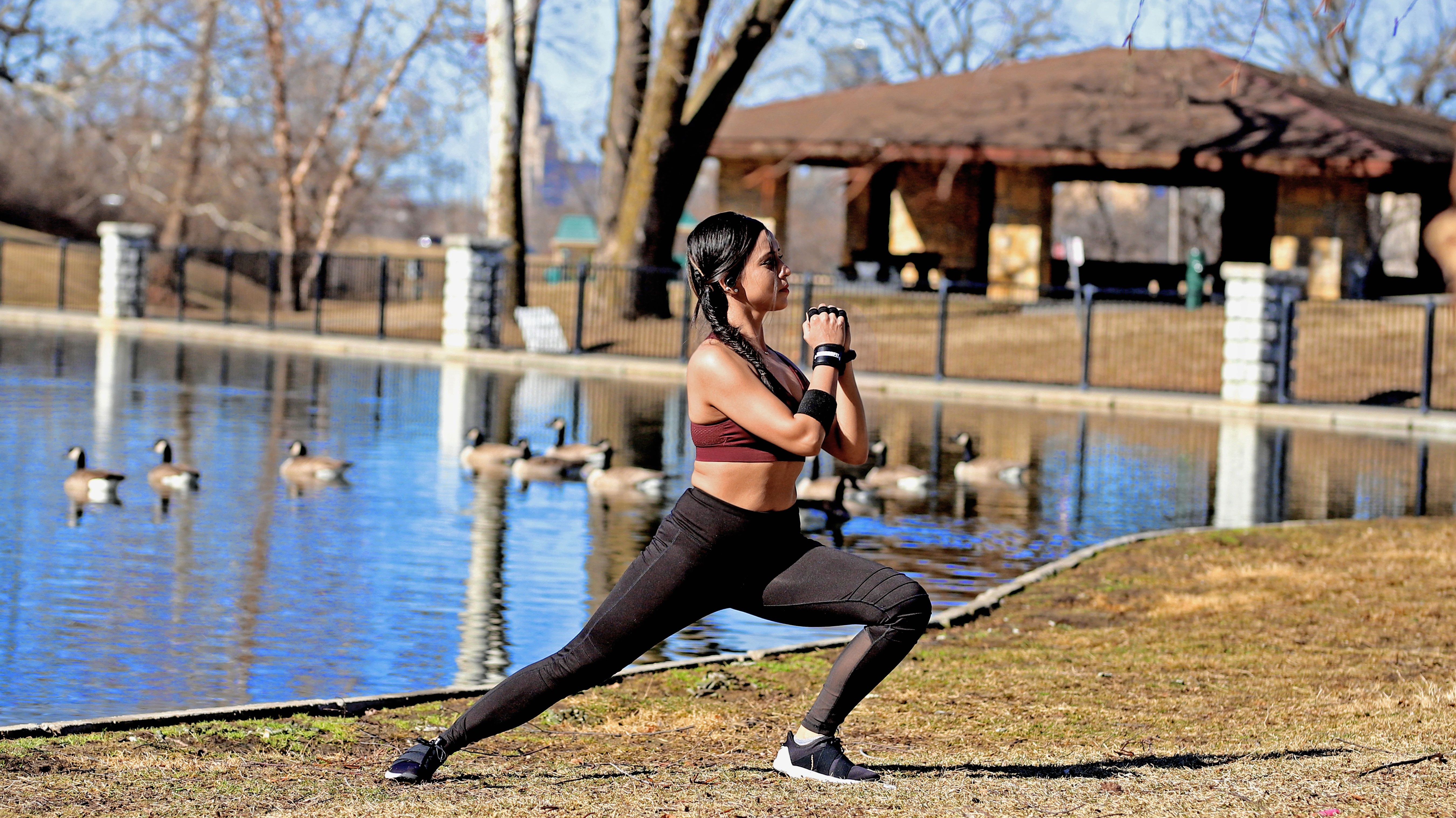 Girl exercising infront of the pond with ducks