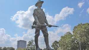 Individual with a gun statue