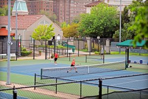Adults playing tennis at the Plaza Tennis Center