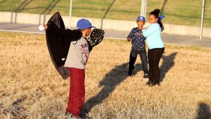 Kids playing baseball wearing KC gear