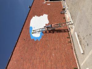 Girl painting on KC wall