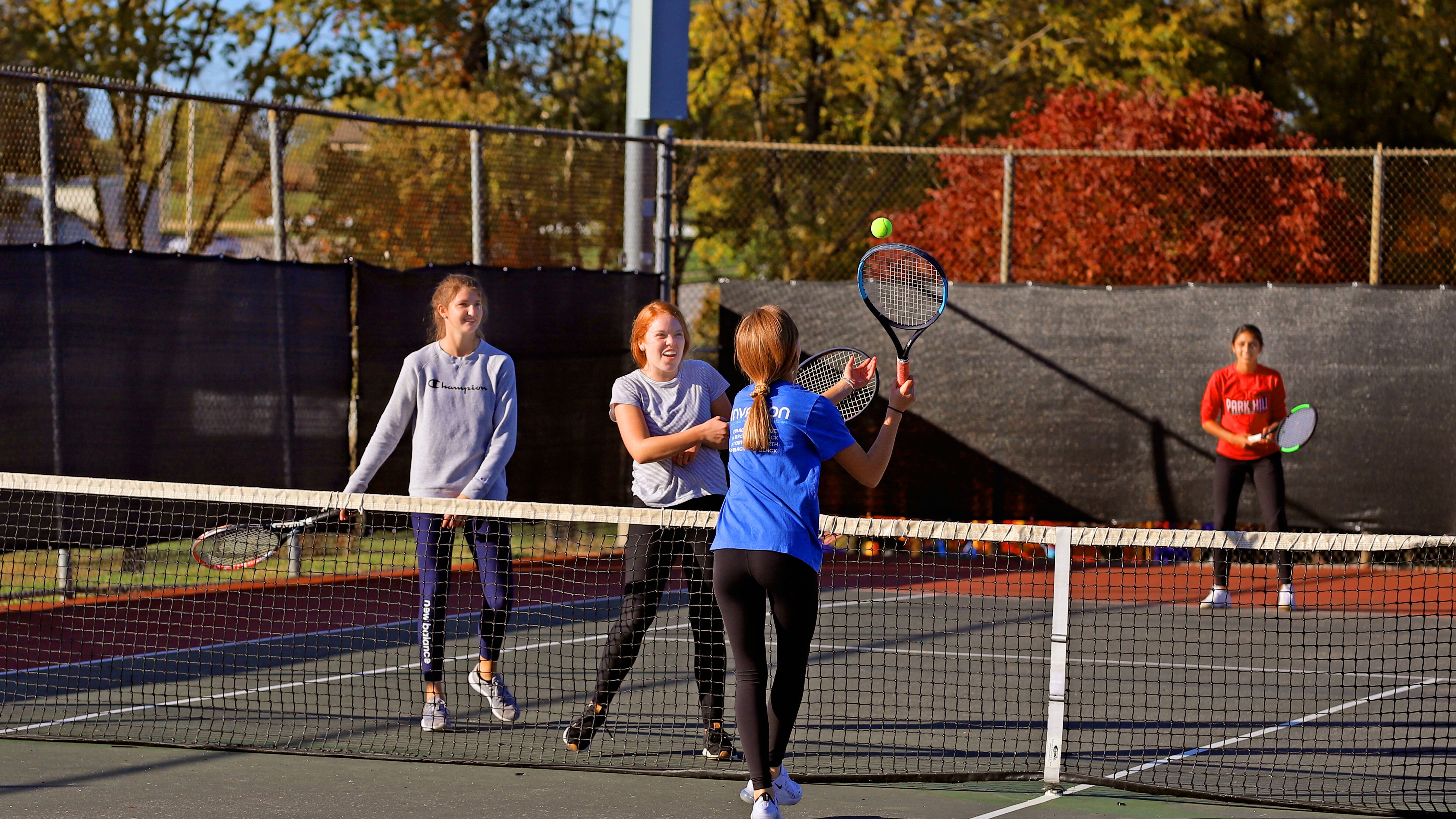 Kids playing tennis in the fall